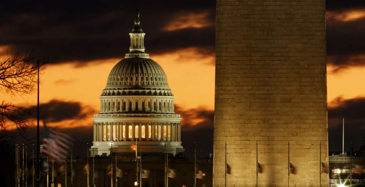 The U.S. Capitol dome is seen past the base of the Washington Monument just before sunrise in Washington, Saturday, Dec. 22, 2018. Hundreds of thousands of federal workers faced a partial government shutdown early Saturday after Democrats refused to meet President Donald Trump's demands for $5 billion to start erecting a border wall with Mexico. Overall, more than 800,000 federal employees would see their jobs disrupted, including more than half who would be forced to continue working without pay. (AP Photo/Carolyn Kaster)