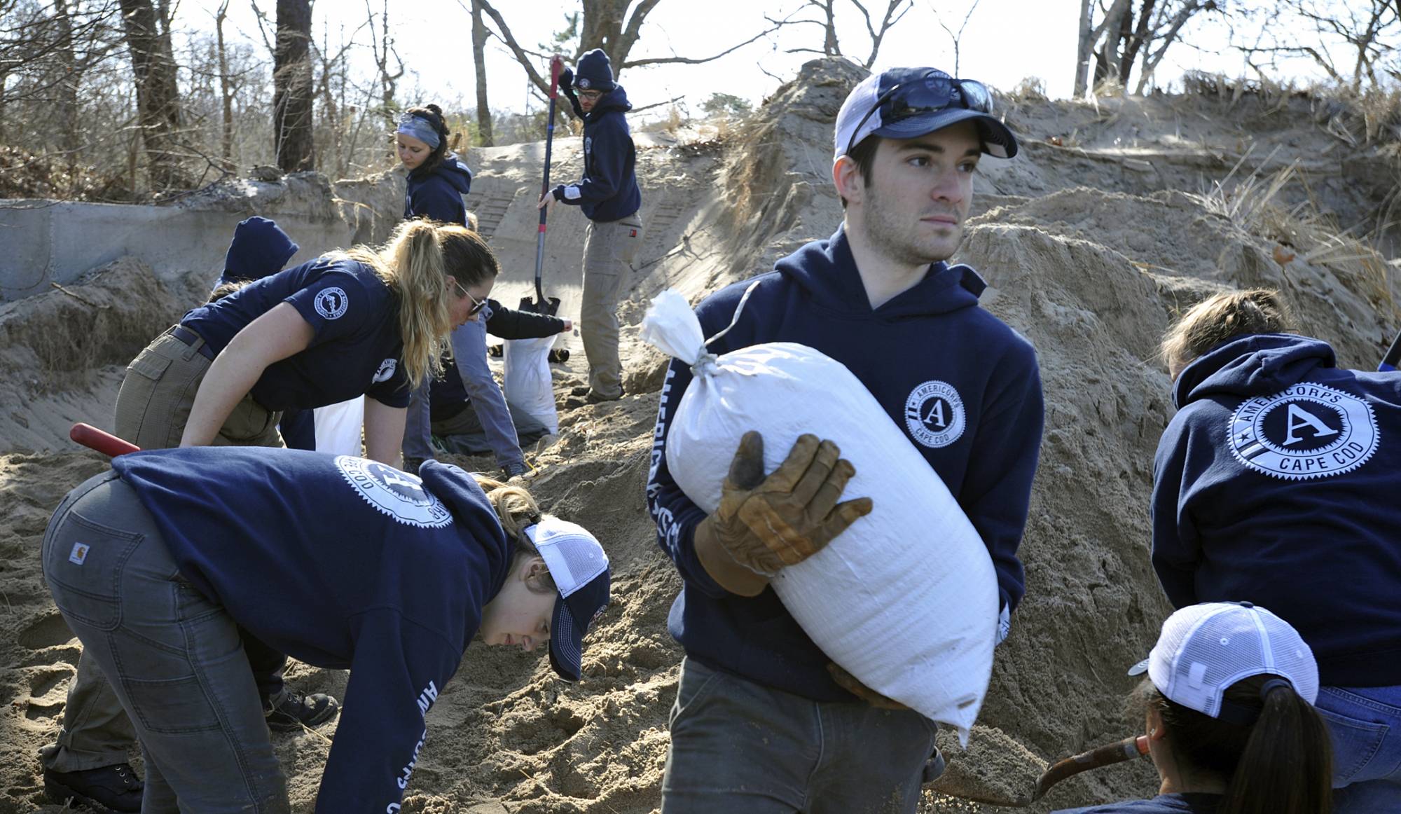 AmeriCorps worker Conor Terry lugs sandbags to a storage area at the town's DPW facility as preparations are underway for the approaching storm, Thursday, March 1, 2018 in Provincetown, Mass. (Steve Heaslip/The Cape Cod Times via AP)