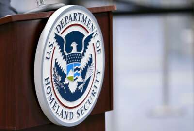 FILE - In this Nov. 20, 2020, file photo a U.S. Department of Homeland Security plaque is displayed a podium as international passengers arrive at Miami international Airport where they are screened by U.S. Customs and Border Protection in Miami. The damned-if-you-pay-damned-if-you-don’t dilemma on ransomware payments has left U.S. officials fumbling about how to respond. While the Biden administration “strongly discourages” paying, it recognizes that failing to pay would be suicidal for some victims. (AP Photo/Lynne Sladky, File)