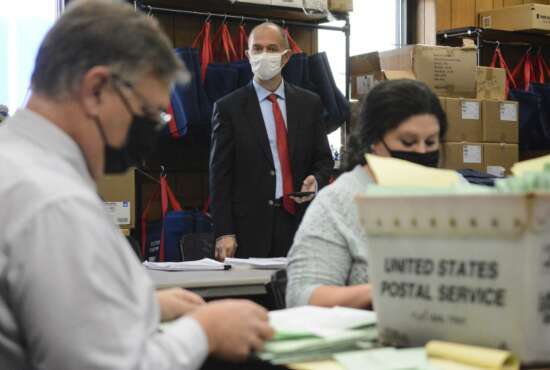 FILE - In this Nov. 10, 2020, file photo, Republican poll watcher Douglas Bucklin, center, observes as Schuylkill County Election Bureau Director Albert L. Gricoski, left, and staffer Christine Marmas, right, open provisional ballots in Pottsville, Pa. Even after he exits the White House, President Donald Trump's scorched-earth strategy of challenging the legitimacy of elections and seeking to overturn the will of the voters by any means necessary could have staying power. (Lindsey Shuey/Republican-Herald via AP, File)