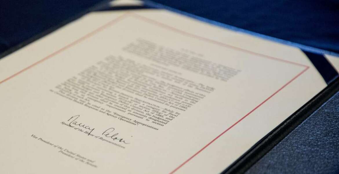 FILE - This March 27, 2020 file photo shows the signature of House Speaker Nancy Pelosi, D-Calif., on the Coronavirus Aid, Relief, and Economic Security (CARES) Act after it passed in the House on Capitol Hill in Washington. Since the pandemic began, Congress has set aside trillions of dollars to ease the crisis. A joint KHN and Associated Press investigation finds that many communities with big outbreaks have spent little of that federal money on local public health departments for work such as testing and contact tracing. (AP Photo/Andrew Harnik, File)